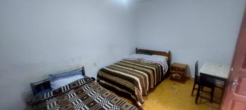 a bedroom with two beds and a desk in it at Casa Dorado - Vallegrande in Vallegrande