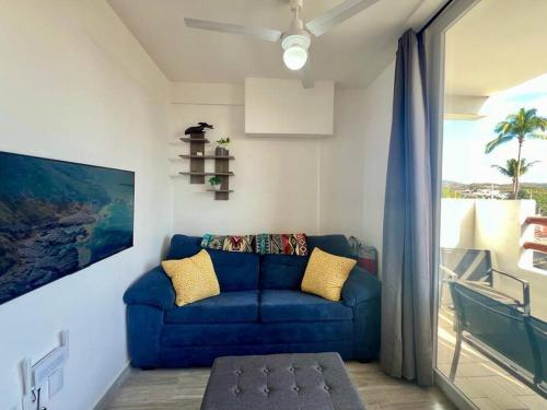 a blue couch in a living room with a window at Elegant Coastal Studio in Bucerías