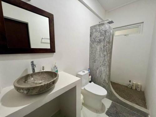 a bathroom with a stone sink and a toilet at Elegant Coastal Studio in Bucerías