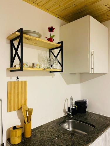 a kitchen with a sink and a counter top at Aconchego Penedo in Penedo