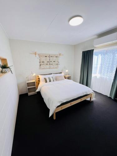 Un dormitorio con una cama grande y una ventana. en Another 'Your Place on Davidson!', en Mount Isa
