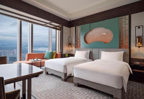 a hotel room with two beds and a couch at Park Hyatt Shenzhen in Shenzhen