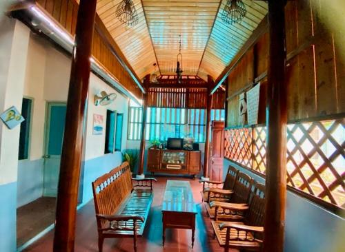 a room with benches and a table in a building at Vietnam Phuot Real Home in Kon Tum