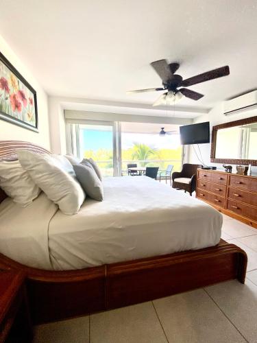 a bedroom with a large bed with a ceiling fan at Villa Magna in Nuevo Vallarta