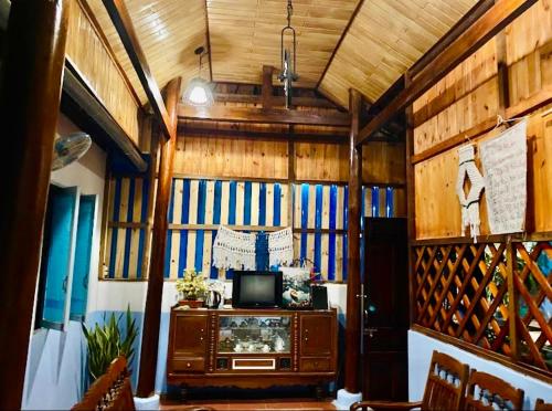 a living room with a tv and wooden walls at Vietnam Phuot Real Home in Kon Tum