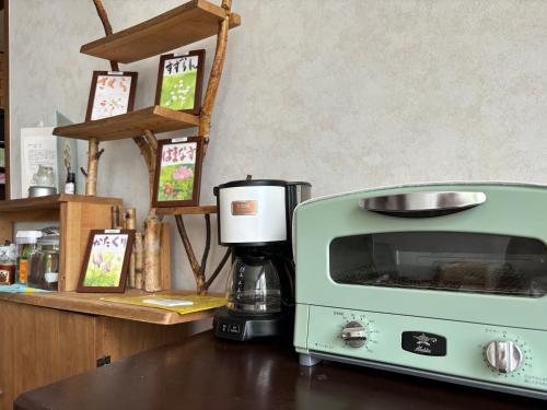 a green toaster oven sitting next to a coffee maker at Guest House 来夢 in Otaru