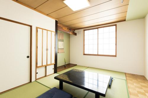 an empty room with a table and a window at Guest House 来夢 in Otaru