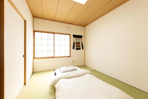 a small room with a bed in the corner at Guest House 来夢 in Otaru