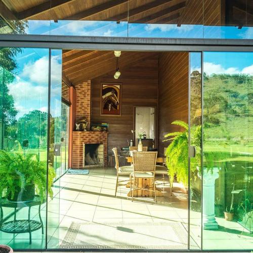a screened in porch with a fireplace in a house at Chalés Rota das Cachoeiras in Urupema