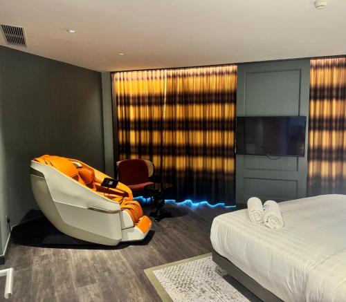 a hotel room with a bed and a chair at The George Penang by The Crest Collection in George Town