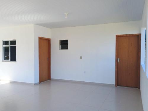 an empty room with two doors and white walls at recanto provetá ILHA GRANDE in Praia de Provetá 