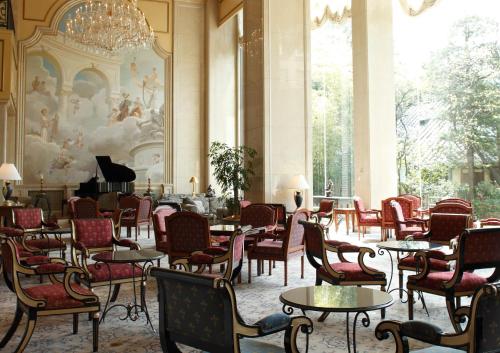 een kamer met tafels en stoelen en een piano bij Rihga Royal Hotel Tokyo in Tokyo