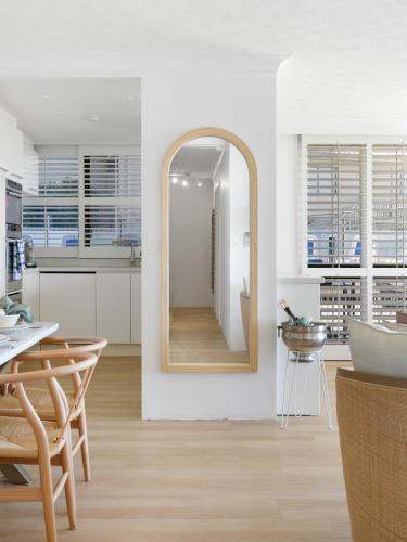 a kitchen with a mirror and a table and chairs at Beach Front Oasis with Private Courtyard in Gold Coast
