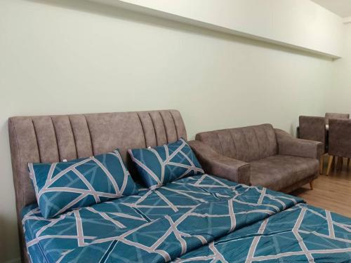 a bedroom with a bed and a couch and a chair at Humaira Dian Residency Studio Homestay 360sqft in Shah Alam