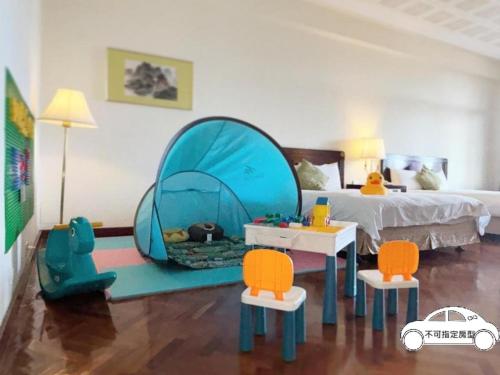 a toy bedroom with a bed and a blue tent at The Grand Hotel Kaohsiung in Kaohsiung