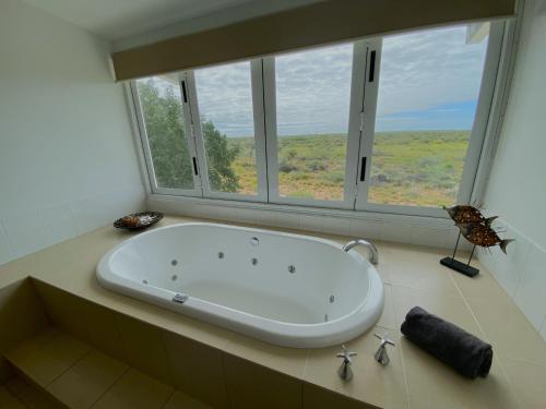 a bath tub in a bathroom with a large window at Osprey Holiday Village Unit 104 in Exmouth