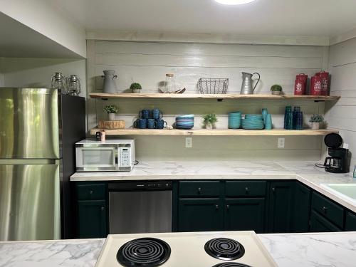 a kitchen with green cabinets and a microwave at The Amazing Escape in Manistee
