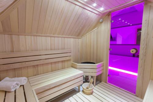 a wooden sauna with purple lighting in a room at Vila Barović and Spa in Zlatibor