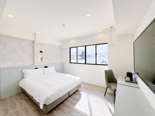 台東市にあるYoai Mountain Roam Hotelの白いベッドルーム(ベッド1台、テレビ付)