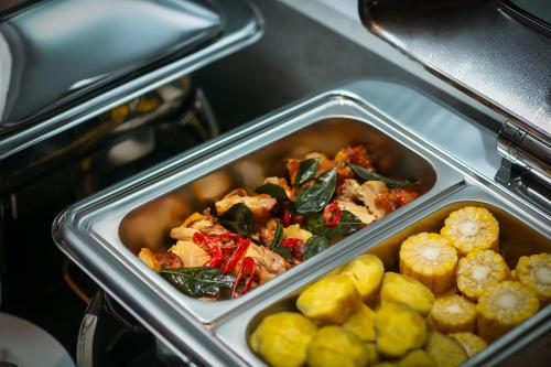 a metal container of food with vegetables in it at MAY DE VILLE Crown Hotel in Hanoi