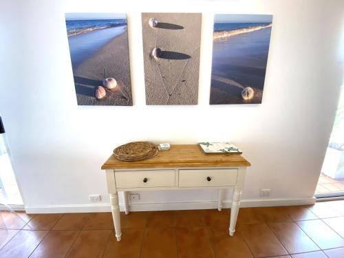 a table in a room with three pictures on the wall at Osprey Holiday Village Unit 109 in Exmouth