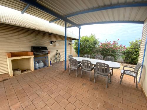 a patio with a table and chairs and a grill at Osprey Holiday Village Unit 109 in Exmouth