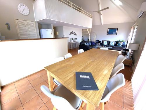 a dining room with a wooden table and white chairs at Osprey Holiday Village Unit 117 in Exmouth