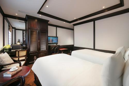 a bedroom with a bed and a desk and a television at MAY DE VILLE Crown Hotel in Hanoi