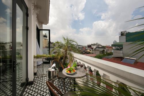 a balcony with a table and chairs on a building at MAY DE VILLE Crown Hotel in Hanoi