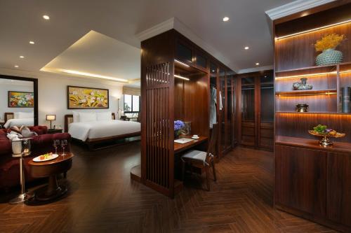a hotel room with a bedroom and a bed at MAY DE VILLE Crown Hotel in Hanoi