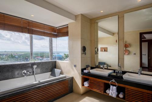 a bathroom with two sinks and a large mirror at tanadewa Villas Nusa Dua Bali by Cross Collection in Nusa Dua