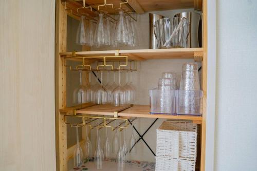 a cabinet filled with glass bottles and glasses at 美らVacation in Onna