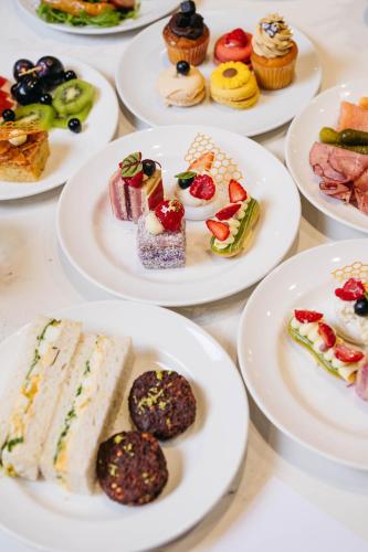 a table topped with plates of desserts and pastries at Sheraton Grand Sydney Hyde Park in Sydney