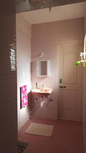 a bathroom with a sink and a door at Casa Amarela in Cuncolim