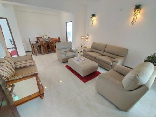 a living room with couches and chairs and a table at Happy Homes Apartment Maharagama in Maharagama