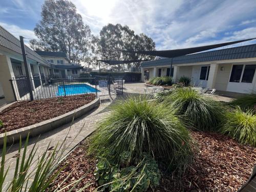 a house with a pool and plants in a yard at Ryley Motor Inn in Wangaratta