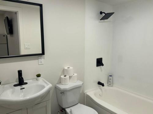 Un baño con inodoro, lavabo y espejo. en Cozy Motel Studio with kitchenette - 8, en Edmonton