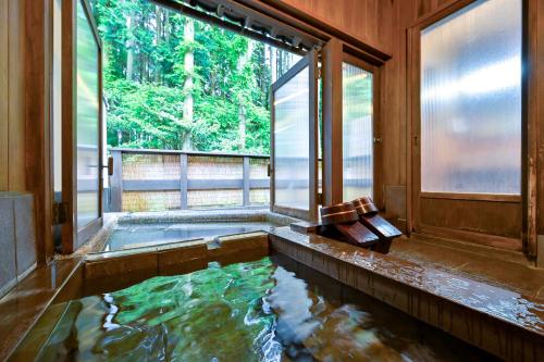 a pool of water in a room with a window at Ikkoten in Yufuin