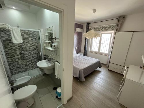 a bathroom with a sink and a toilet and a bed at F.Rooms Napoli in Naples