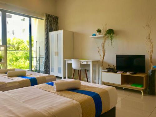 Una habitación de hotel con dos camas y un televisor. en Sunset Seaview Vacation Condos @ IMAGO Shopping Mall, en Kota Kinabalu