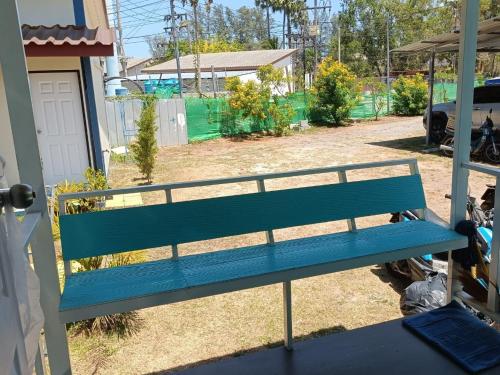a blue bench sitting outside of a house at Chill land house in Bang Tao Beach
