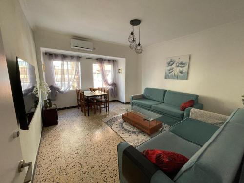 a living room with a blue couch and a table at La perle de Benicarló 2 in Benicarló