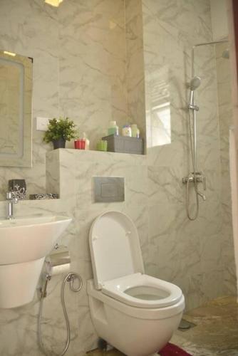 a bathroom with a toilet and a sink and a shower at Happy Homes Apartment Maharagama in Maharagama