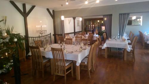 a dining room with white tables and chairs and a christmas tree at Hotel Rüstersieler Hof in Wilhelmshaven
