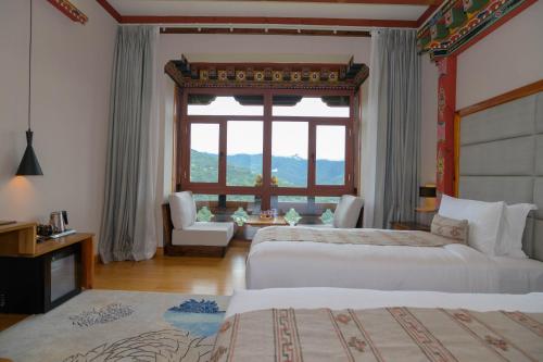 a bedroom with two beds and a large window at Willing Resort, Trongsa in Kagha