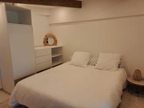 une chambre avec un lit blanc avec deux oreillers dans l'établissement Les Bruyères, à Marseille