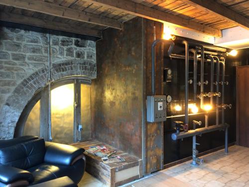 a living room with a couch and a stone fireplace at APPARTEMENT style loft industrielle de 250m2 in Longwy