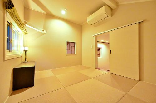 an empty room with a door and a window at Ikkoten in Yufuin