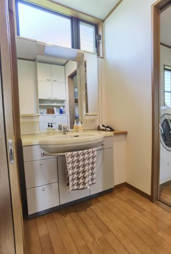 a bathroom with a sink and a mirror at リニューアル 高島市風車村琵琶湖畔別荘サウナ付きファミリーグループ大歓迎テラス炭火BBQ Reiwa House in Takashima