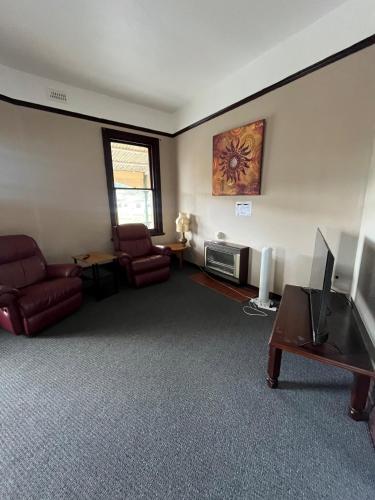 a living room with two chairs and a flat screen tv at St Marys Hotel in Saint Marys